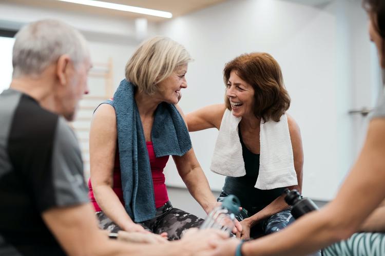 A group of seniors smiling and laugh together after an exercise class in their retirement community